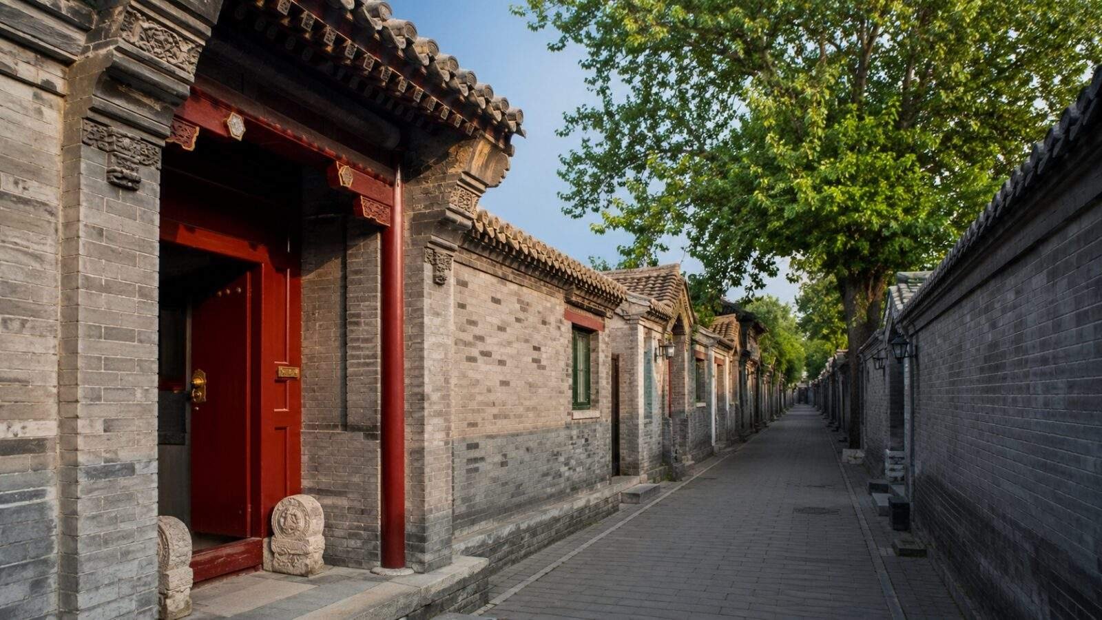 Traditional Beijing hutong lane with grey brick courtyard walls in daylight