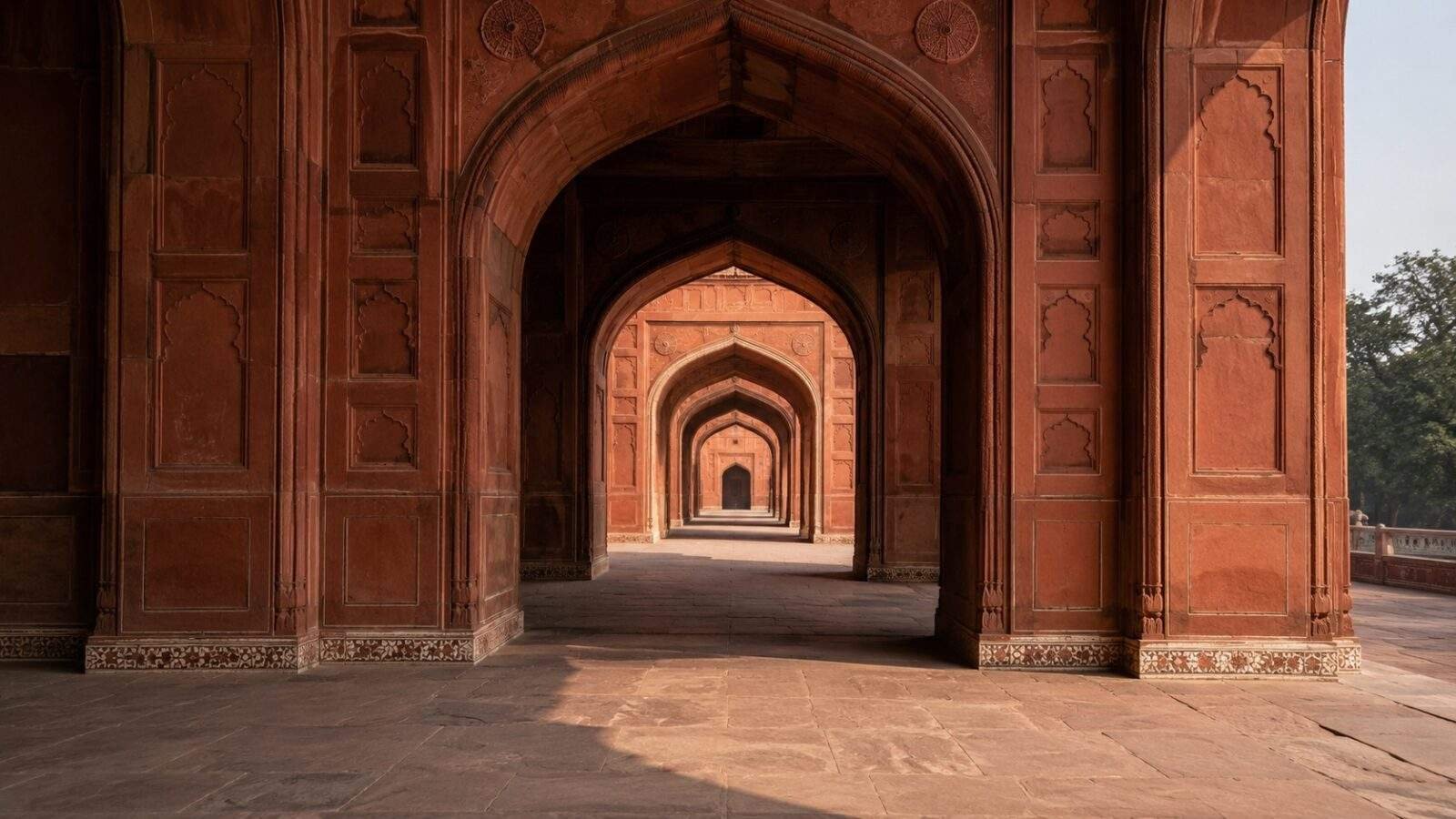 Red sandstone Mughal archways in Agra with sharp geometric shadows
